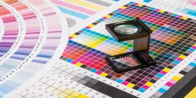 A printer's loupe on a colour-swatch sheet.